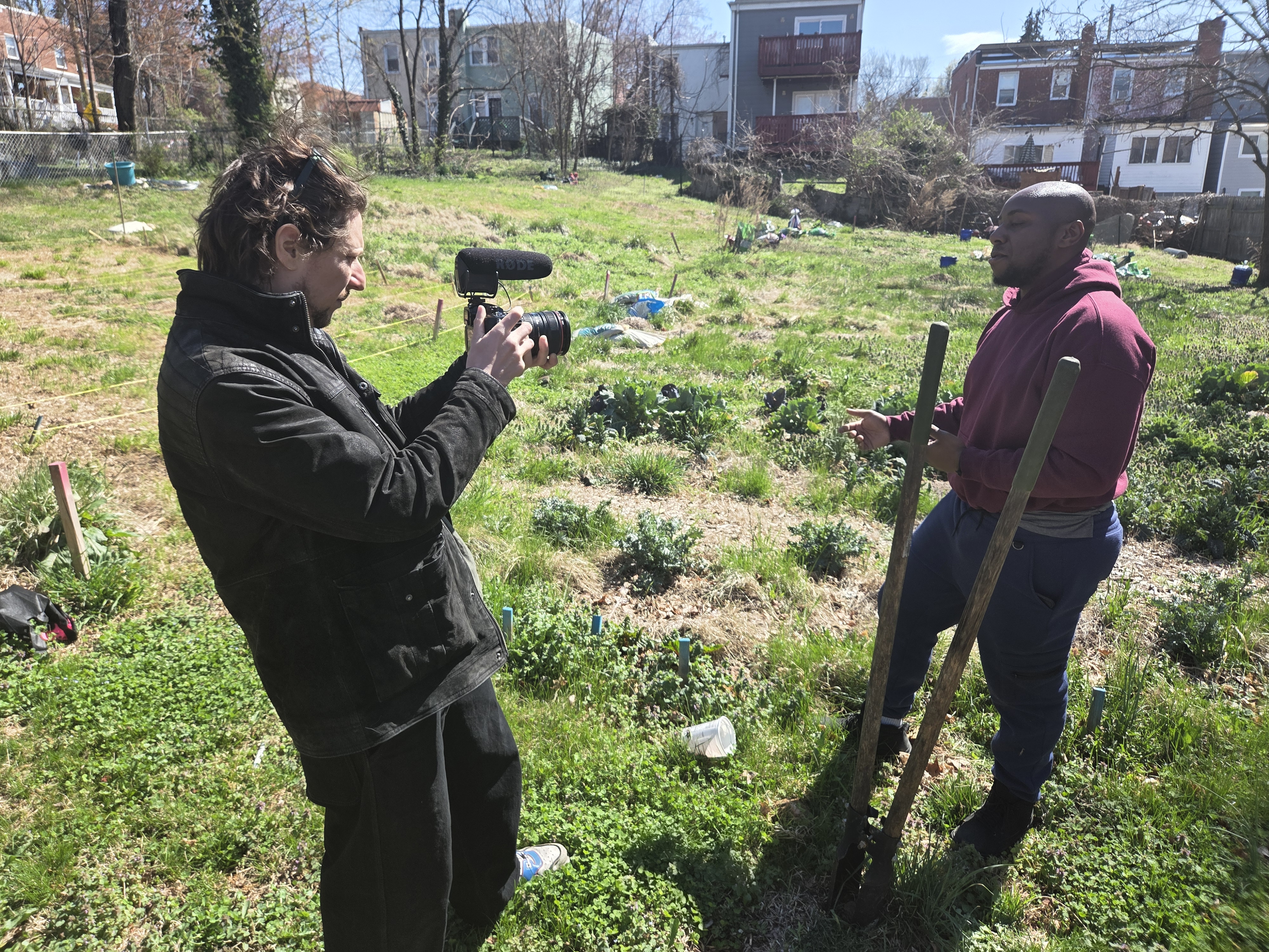 Manny walking a vacant lot as the crew films